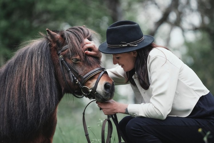 a woman with a pony, facing each other, showing the mirroring